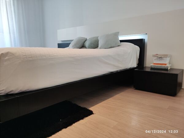 cama de casal com mesas de cabeceira. Camas
